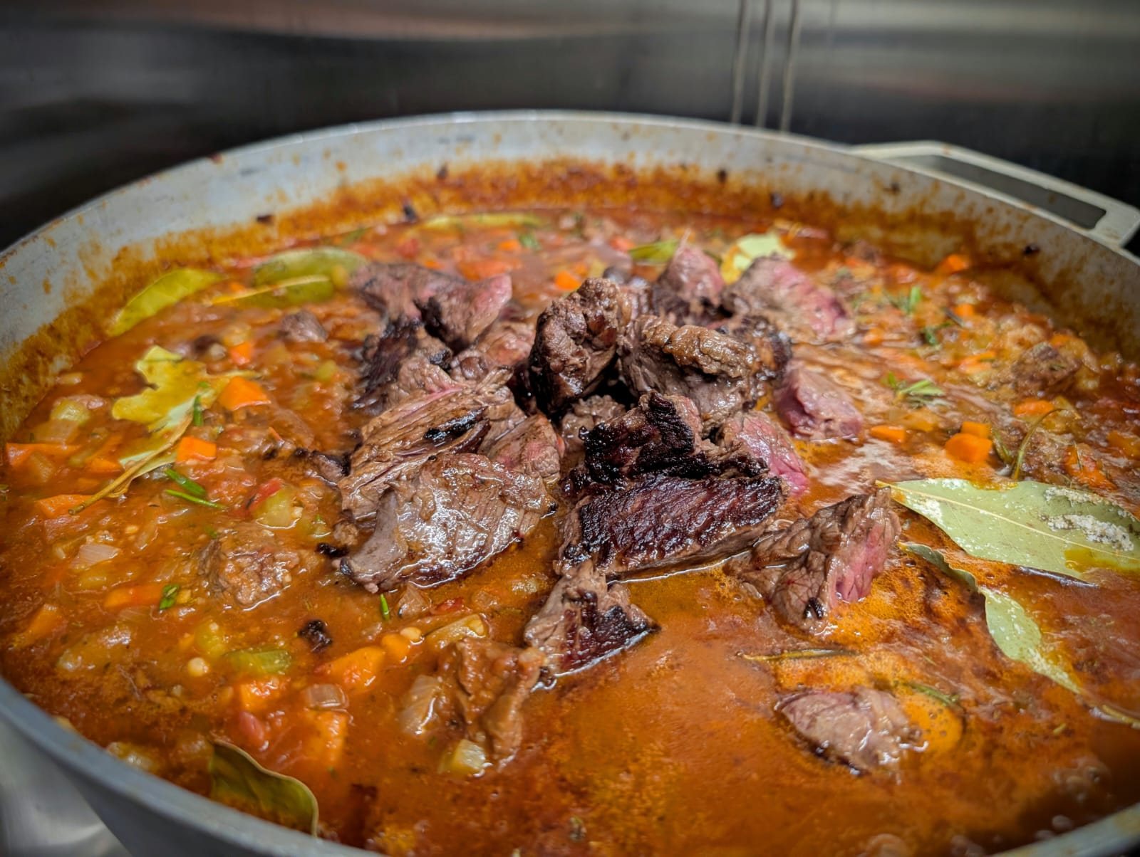 A large pot of Beef Bourguignon simmering in the Chez Leon kitchen, prepared for the community meal program.