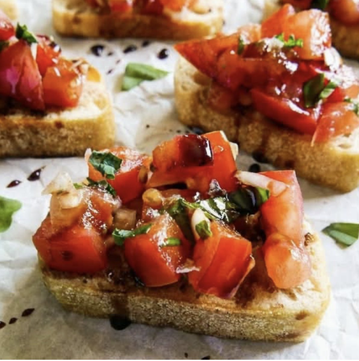 Bruschetta topped with diced tomatoes, basil, and balsamic glaze.