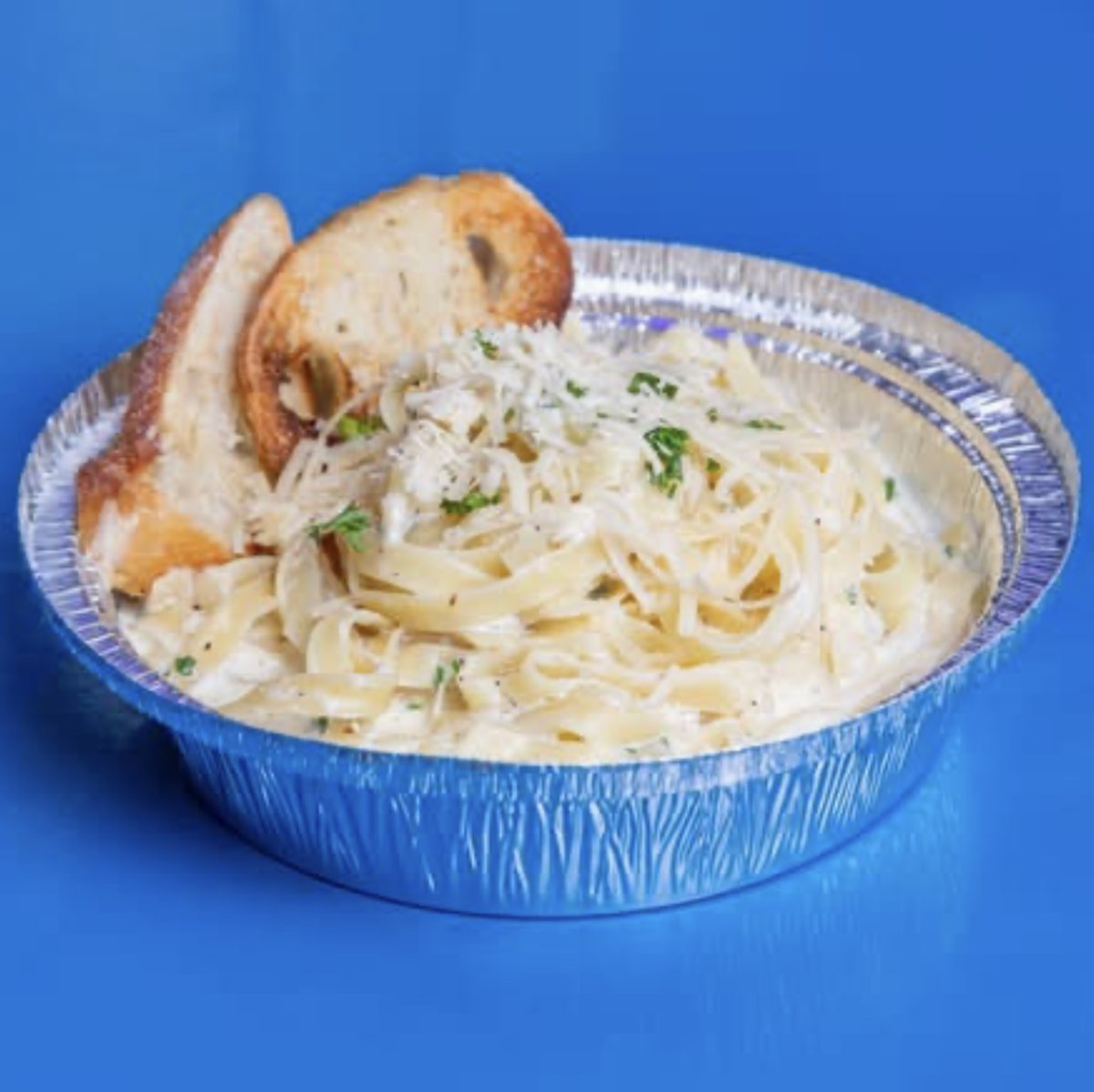 Linguine Alfredo with grilled chicken, topped with Parmesan and parsley, served with garlic bread.