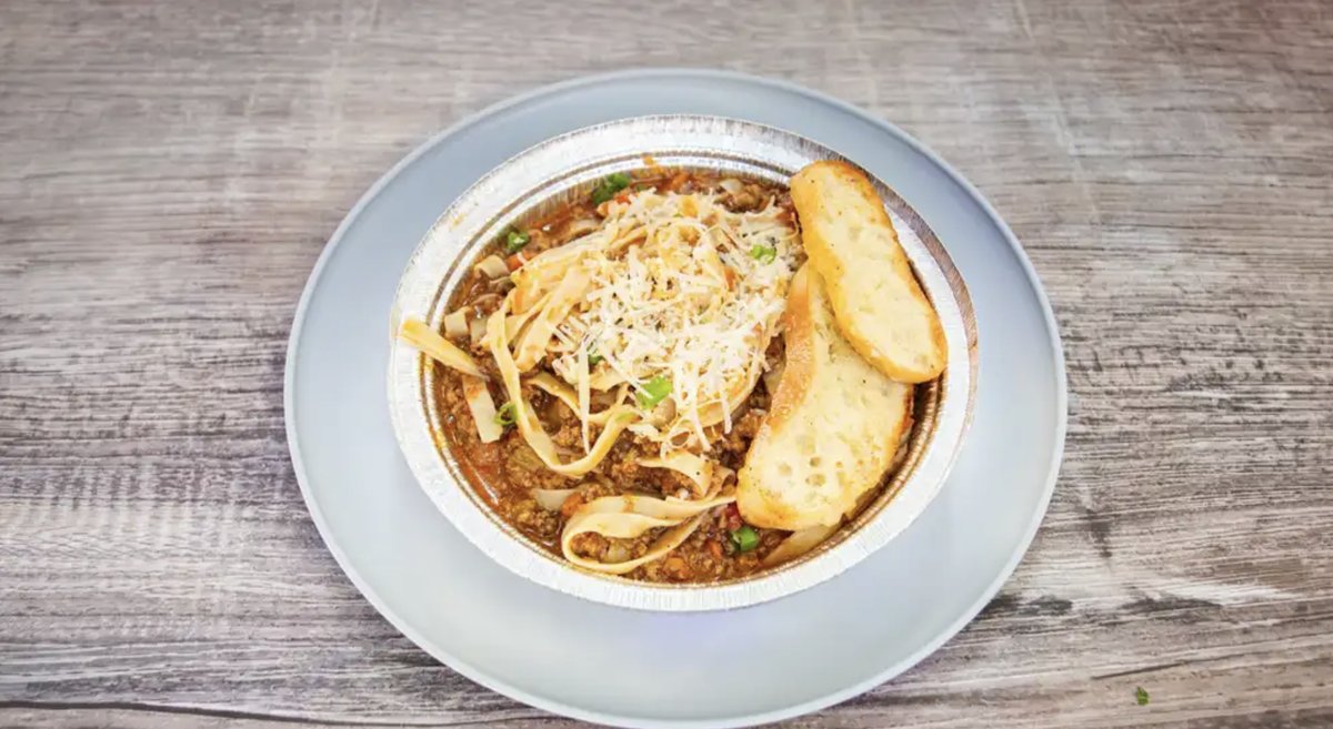 Linguine Bolognese topped with shredded Parmesan, served with garlic bread.