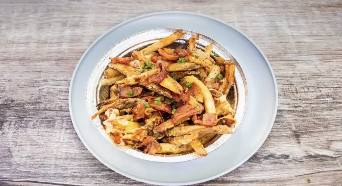Leon's Smothered Fries topped with Swiss cheese, maple bacon, and green onions.